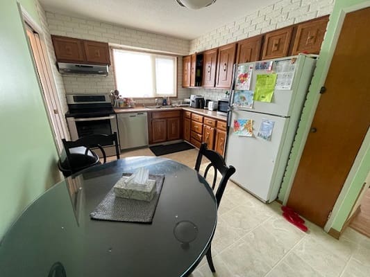Small kitchen with wooden cabinets and table.