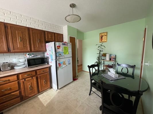 Kitchen with wooden cabinets and dining table.