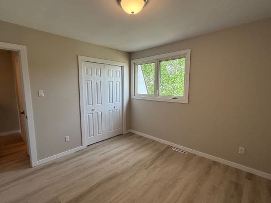 Empty room with window and closet door.