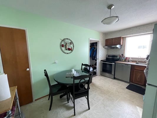 Small kitchen with dining table and chairs.