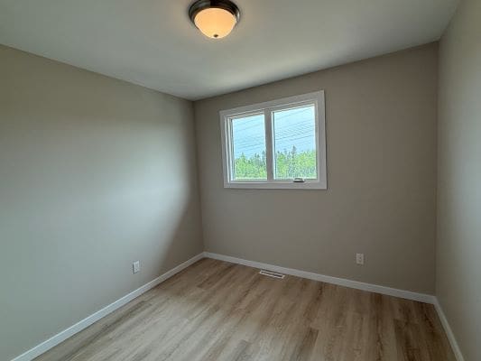 Empty room with window and light fixture.