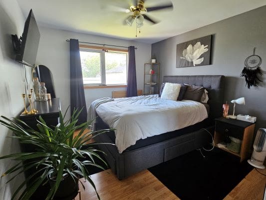 Modern bedroom with bed and decor items.