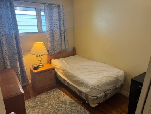 Small bedroom with bed and lamp.