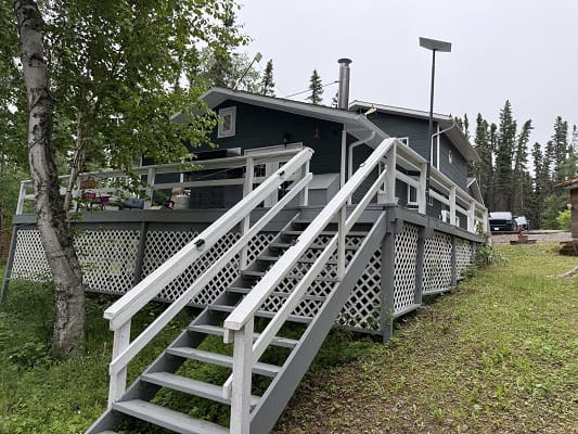 Elevated wooden house with front staircase.