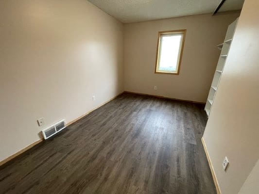 Empty room with wooden floor and window.
