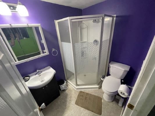 Small bathroom with purple walls and shower.
