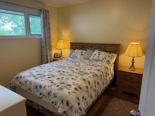 Cozy bedroom with double bed and lamps.