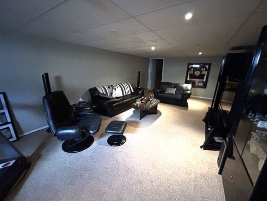 Basement lounge with black leather furniture.