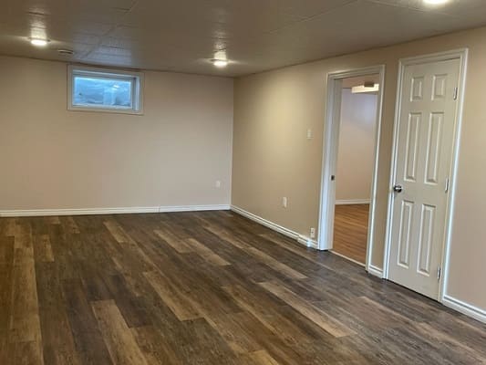 Empty room with wooden floor and doorway.