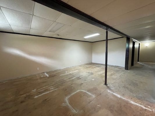 Empty basement with exposed concrete floor.