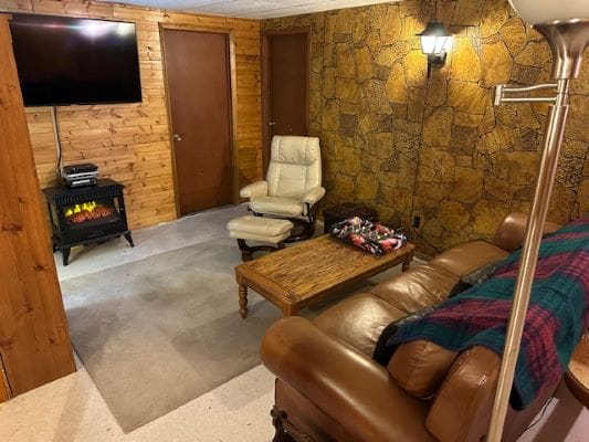 Cozy basement room with fireplace and seating.