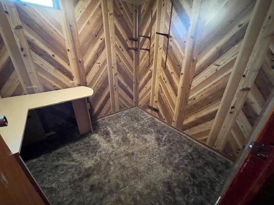 Room with wooden walls and desk.