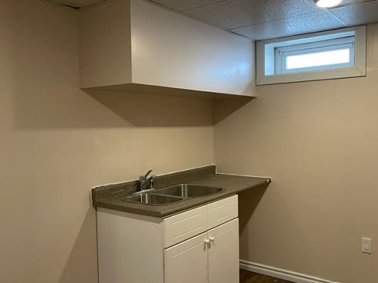 Small kitchen sink with overhead cabinet.