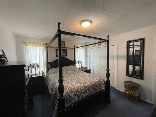 Four-poster bed in cozy bedroom.