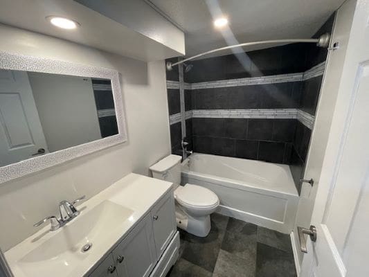Modern bathroom with bathtub and dark tiles.