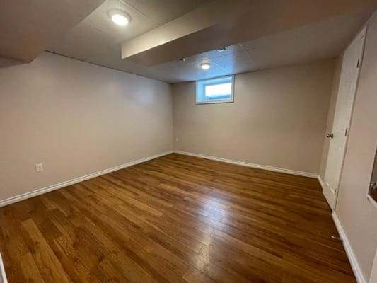 Empty room with wooden floor and window.