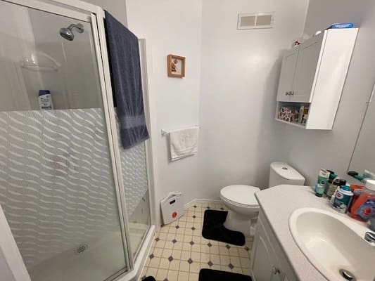 Small bathroom with shower and sink.