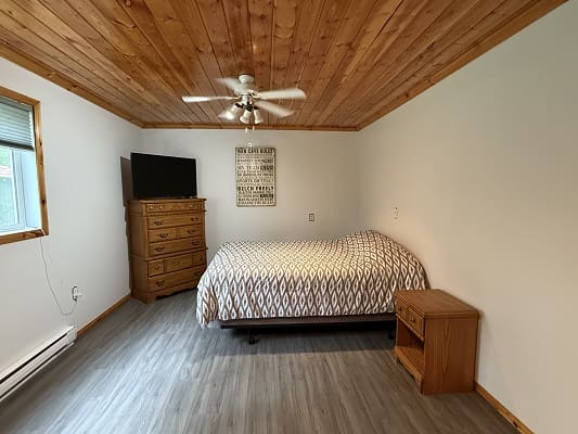 Bedroom with wooden ceiling and modern furniture.