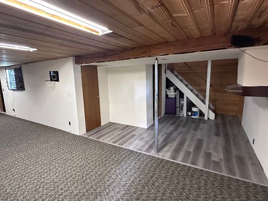 Basement with wooden ceiling and carpet flooring.