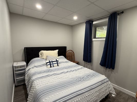 Cozy bedroom with bed and blue curtains.
