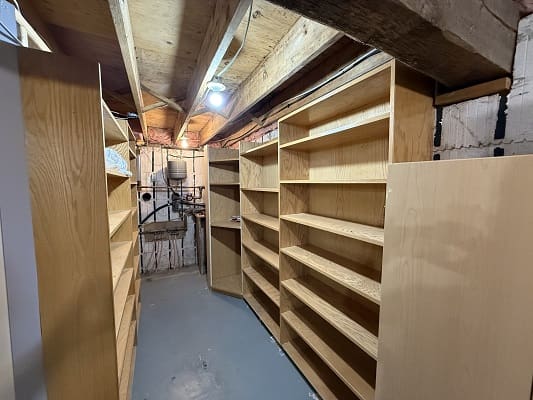 Wooden shelves in a basement storage room.