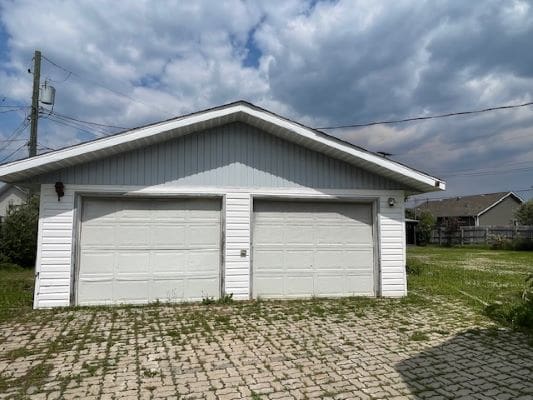 White double garage with cloudy sky.