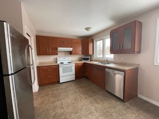 Modern kitchen with wooden cabinets and appliances.