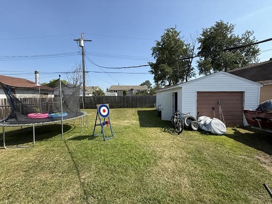 Backyard with trampoline and storage shed.