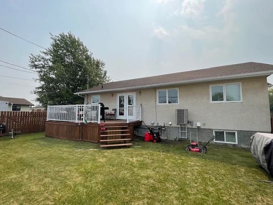Single-story house with backyard and deck.