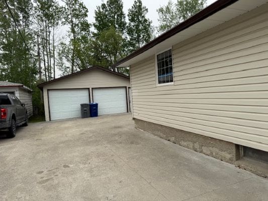 Driveway with garages and parked vehicle.