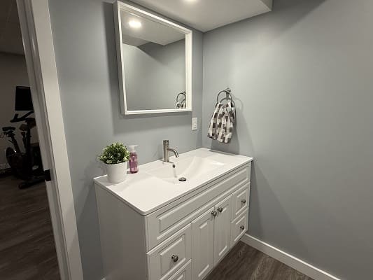 Modern bathroom vanity with mirror and sink.