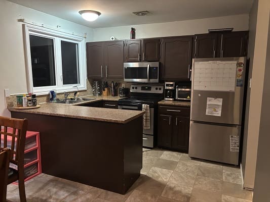Modern kitchen with dark cabinets and appliances.