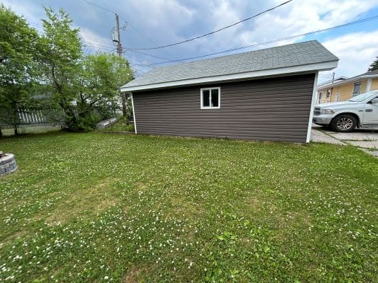Garage with grassy yard and parked car.