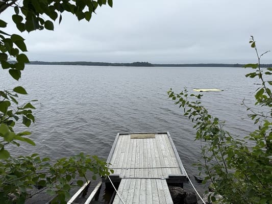 Dock extending into calm, overcast lake scene.