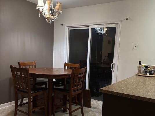 Dining area with round table and chandelier.