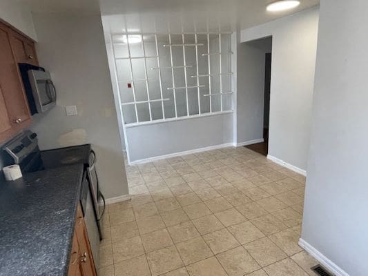 Kitchen with tiled floor and glass partition.
