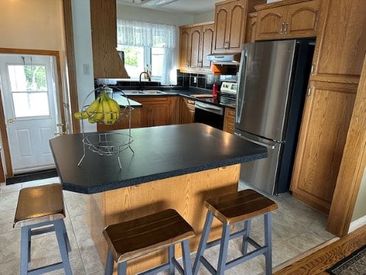 Modern kitchen with island and stainless appliances.