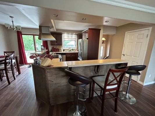 Modern kitchen with bar stools and dining area.