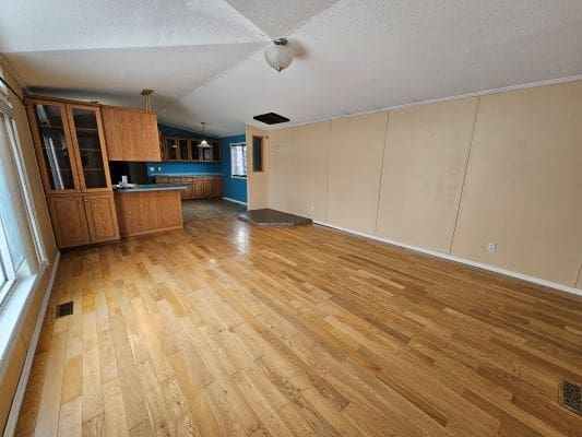 Spacious empty room with wooden flooring.