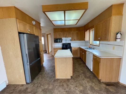 Wooden kitchen with modern appliances and island.