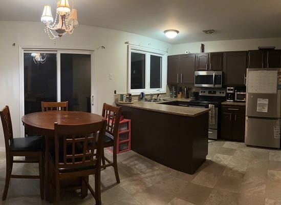 Modern kitchen with dining table and chandelier.