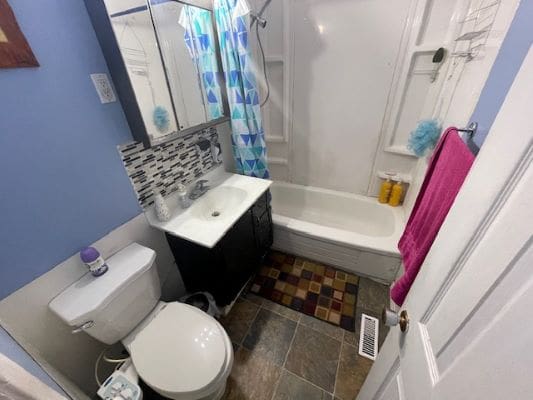 Small bathroom with tub and tiled floor.
