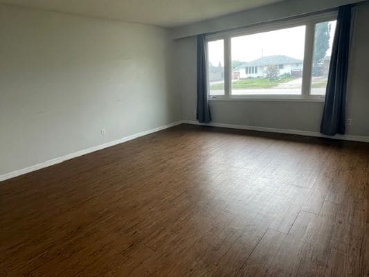 Empty room with wooden floor and window.