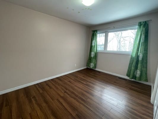 Empty room with wooden floor and window.
