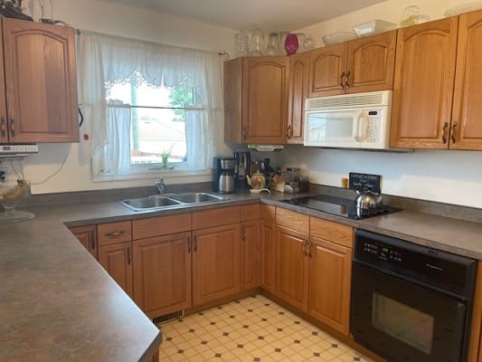 Wooden kitchen cabinets with appliances and window.