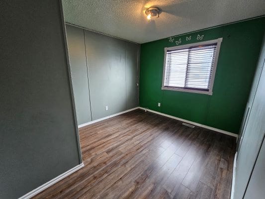 Empty room with wooden floor and window.