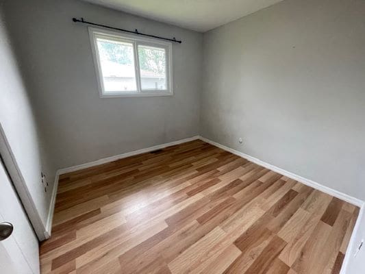 Empty room with wooden floor and window.