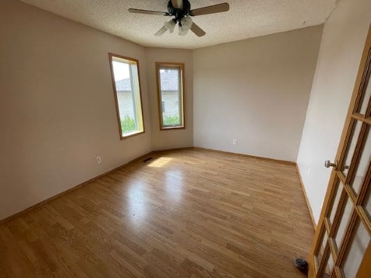 Empty room with wooden floor and windows.