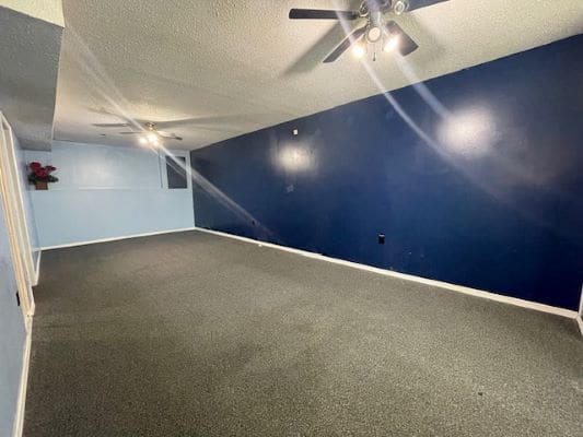 Spacious room with blue accent wall.