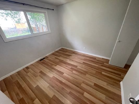 Empty room with wooden floor and window.